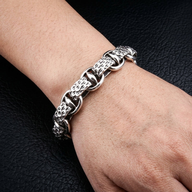 Snake-scale sterling silver bracelet worn on a wrist, showing raised scales and smooth connecting links.