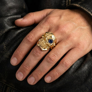 Solid 14k gold skull ring with sapphire eye and diamond tooth alternate worn view for scale