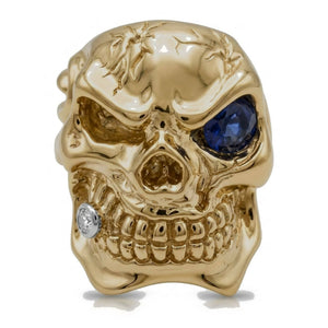 Solid 14k gold skull ring with sapphire eye and diamond tooth — front view