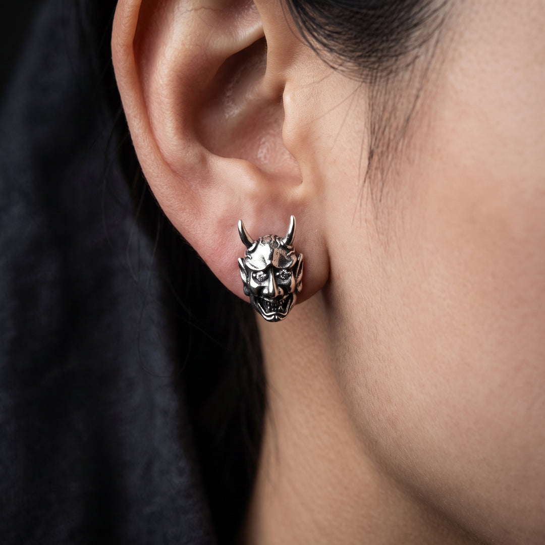 Oni demon sterling silver stud earring shown at realistic scale on an ear