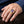 Gold-plated amethyst bishop ring worn on a hand, showing the purple cushion stone, clear halo and fleur-de-lis shoulder.