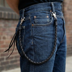 Black Braided Leather Wallet Chain with Tassels, styled between denim belt loops