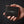 Homme tenant un grand portefeuille deux volets en cuir de raie noir avec bordure corail