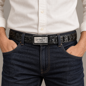 Black crocodile hornback ratchet belt worn with dark jeans and an off-white shirt