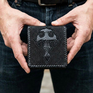 Black lizard and shark skin cross bifold wallet held in hands, front view