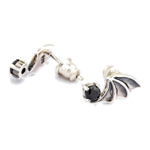 Boucles d'oreilles puces ailes de chauve-souris en argent sterling 925 et oxyde de zirconium noir. Une aile est vue de face tandis que l'autre montre l'arrière de son serti et sa tige.