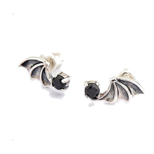 Boucles d'oreilles puces ailes de chauve-souris en argent sterling 925 et oxyde de zirconium noir. Les ailes en miroir sont inclinées pour montrer les membranes sombres en creux à côté des oxydes de zirconium noirs.