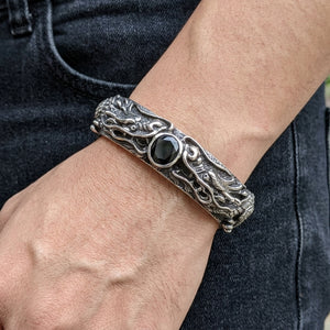 Bracciale rigido aperto con doppio drago in argento sterling e CZ nero, indossato naturalmente al polso con la chiusura visibile