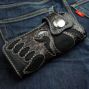 Lang bikerlommebok i svart rokkeskinn med demon, lommebok på denim vinkel forfra
