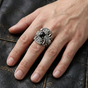 Black stone cross and skull silver ring on a natural five-finger hand