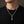 Collier tête de mort en argent sterling à crête iroquoise en pierres noires et maillons en forme de crâne, porté sur un t-shirt noir à col rond.