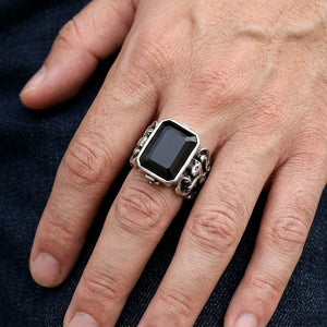 Anillo de plata esterlina con león escocés y circonita cúbica negra, llevado en un dedo medio en un primer plano natural de la mano