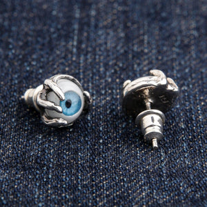 Oorknoppen met blauwe oogbal en klauwen van sterling zilver. Eén oogbal wijst naar voren terwijl de andere omgedraaid is om de zilveren achterzijde en de stift te tonen.