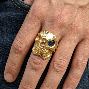 Blue Eye Gold-Plated Sterling Silver Skull Ring, worn on an adult model