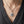 Blue acrylic-eye silver pendant styled on a silver chain above a charcoal shirt neckline; chain sold separately.