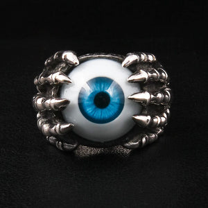 Anillo de plata esterlina con garra esquelética y ojo azul, anillo de garra con ojo en plata esterlina con un ojo azul realista sostenido por una mano esquelética, mostrado en