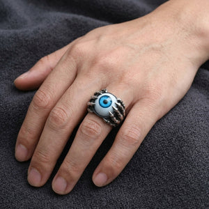 Anillo de plata esterlina con garra esquelética y ojo azul llevado en una mano