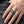 Bague croix de fer en argent sterling avec saphir bleu portée sur une main d'adulte, montrant les détails de face et d'épaulement.