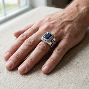 Bague croix halo en argent sterling et oxyde de zirconium bleu portée sur une main détendue