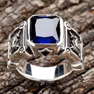 Ein massiver Ritterring aus 925 Sterlingsilber mit einem großen, rechteckigen blauen Stein und aufwendig geschnitzten Schilddetails an der Seite