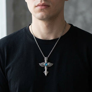 Blue-stone winged silver cross pendant worn over a black shirt; chain shown for styling