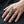 Anillo de cráneo de cálao en plata esterlina 925 con topacio azul puesto en una mano