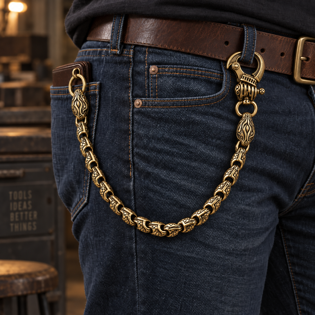 Brass viper wallet chain with engraved links fastened between a belt loop and wallet on blue jeans