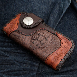Brown crocodile wallet on denim with raised scales, floral leather ends and a round concho.