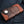 Oblique front view with raised crocodile scales framed by orange-brown floral leather.