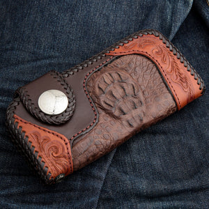 Oblique front view with raised crocodile scales framed by orange-brown floral leather.