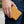Portfel bifold ze skóry strusia w kolorze butter tan trzymany przy ciemnym denimie