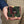 A hand holds the camouflage stingray bifold with tan trim and its pale pearl cluster visible.