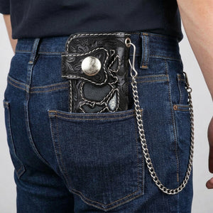 Closed carved skull biker wallet in a man’s back jeans pocket, styling chain hooked directly into the inset silver eyelet at the wallet’s upper right edge; chain not included