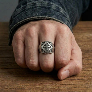 Sterling silver Celtic cross ring on a closed fist, showing the complete cross and shield design