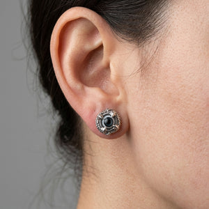 Small claw eyeball sterling silver stud earring worn on ear in close profile view