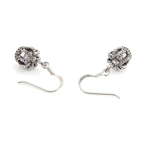Boucles d'oreilles pendantes en argent sterling avec couronne et oxyde de zirconium transparent. Les couronnes reposent à côté de leurs crochets d'oreille incurvés et de spirales enroulées.