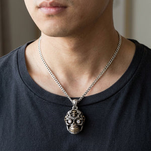 Pendentif tête de mort mexicaine aux yeux clairs en argent sterling 925, présenté sur une chaîne en argent avec une chemise sombre