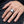 Clear stone dragon claw sterling silver ring worn on an adult hand resting on dark denim, showing the faceted center and sculpted silver shoulder.