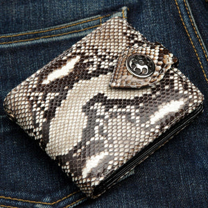 Concho-plånbok i kobraskinn, stängd framsida i vinkel på denim