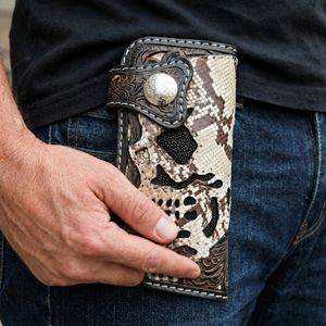 Cobra and Stingray Skull Leather Biker Wallet, held by a model at hip level