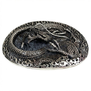 Hebilla de cinturón con dragón enrollado en plata de ley .925 mostrando el relieve elevado del dragón desde un ángulo bajo.