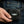 Compact Black Stingray Cross Bifold Wallet held in one hand against blue jeans