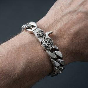 Crown clasp silver Cuban bracelet worn on a wrist, showing the broad links and engraved clasp