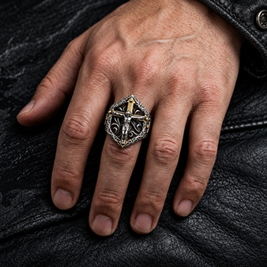 Crucifix silver ring with raised silver figure worn against black biker leather