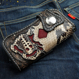 Portefeuille crâne démoniaque en cobra et galuchat rouge — vue en biais sur du denim