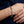 Dorje link silver bracelet worn across a relaxed wrist, showing the engraved lobster clasp.