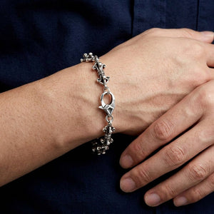 Dorje link silver bracelet worn across a relaxed wrist, showing the engraved lobster clasp.