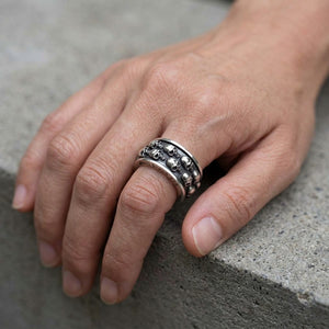 Anillo giratorio con doble calavera de plata de ley puesto en una mano