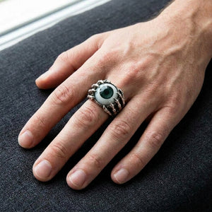 Bague griffe de dragon en argent sterling portée sur une main avec un iris de globe oculaire vert foncé profond