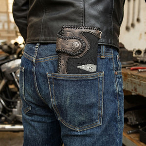 Long tooled leather and stingray wallet inserted into a rear jeans pocket beneath a black leather jacket, with the dragon concho visible.